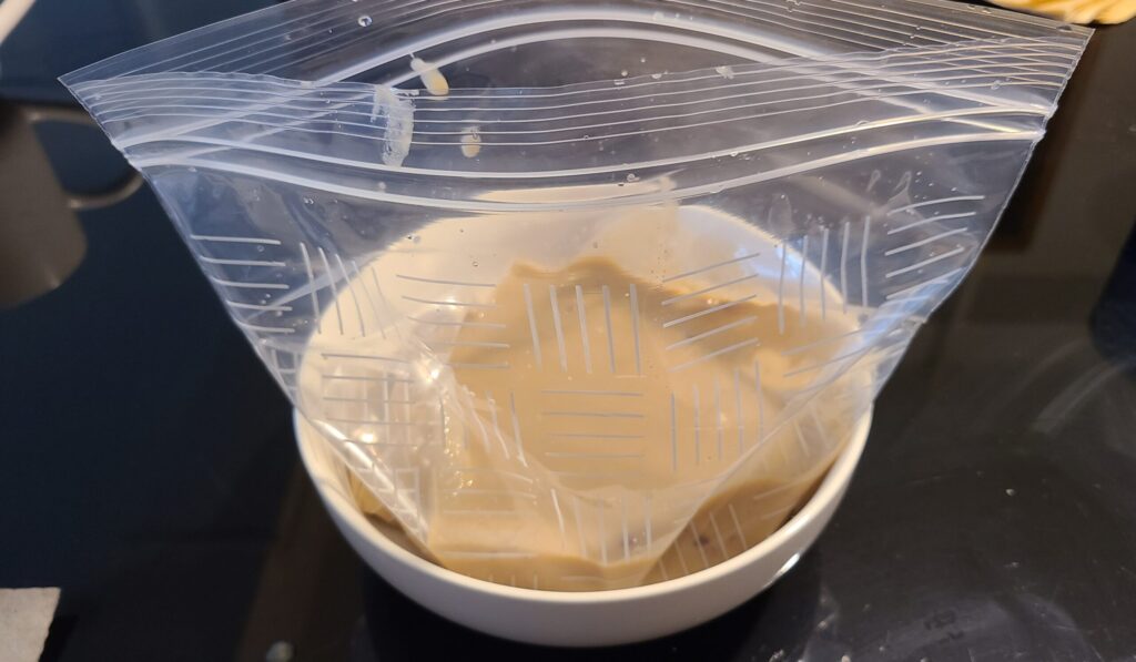 液状のさつま芋と豆乳のアイスクリームが透明の袋に入っている様子。