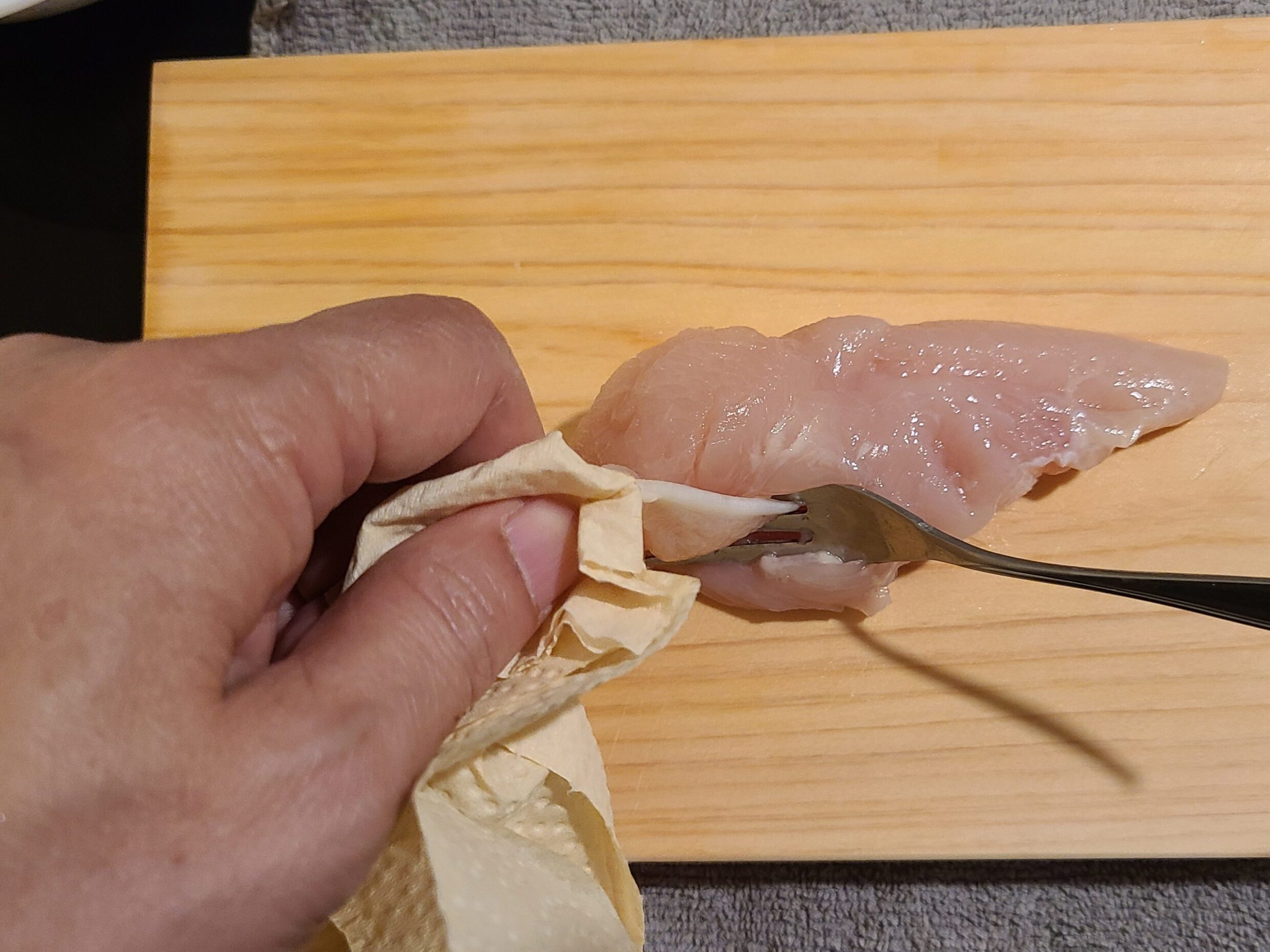 フォークを使ってささみの筋をとっていいる様子。