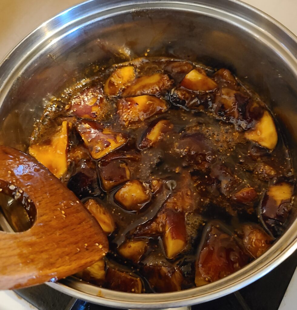 鍋でカットしたいちじくと砂糖を木べらで混ぜながら煮ている様子