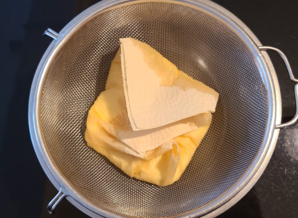 ヨーグルトをキッチンペーパーで包んで切る様子