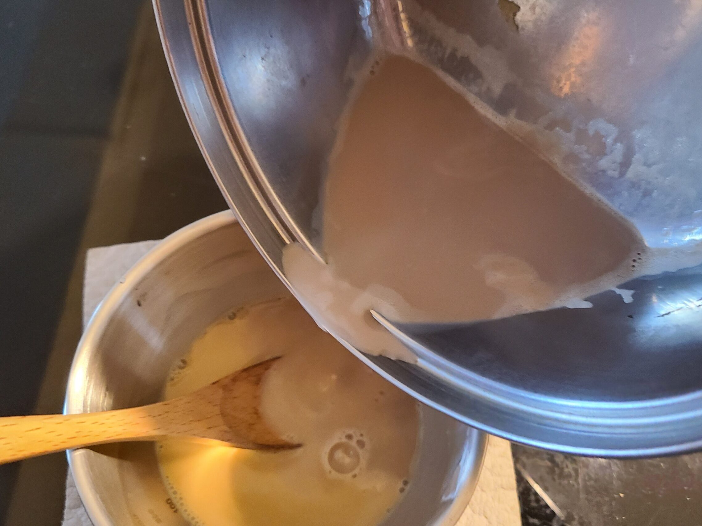 溶き卵と少量の豆乳が入ったボウルに、温めた豆乳を入れている様子。