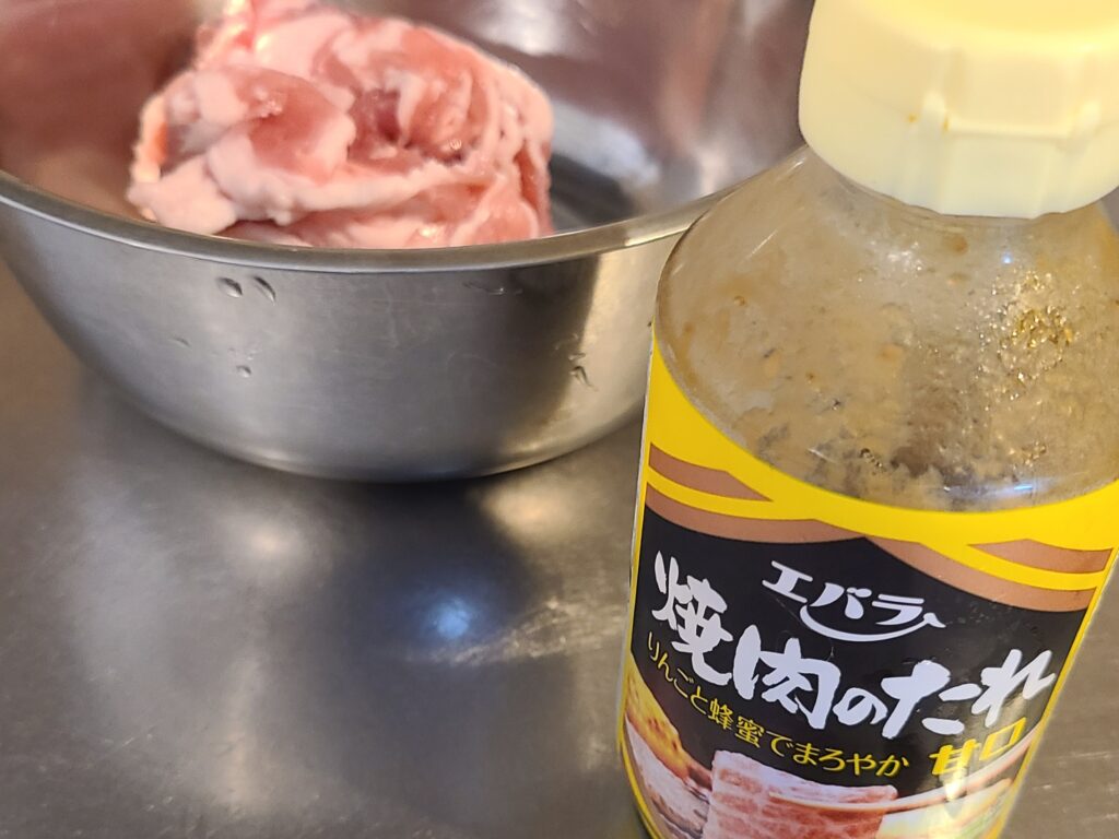 ボウルに入っている豚肉と焼肉のタレ