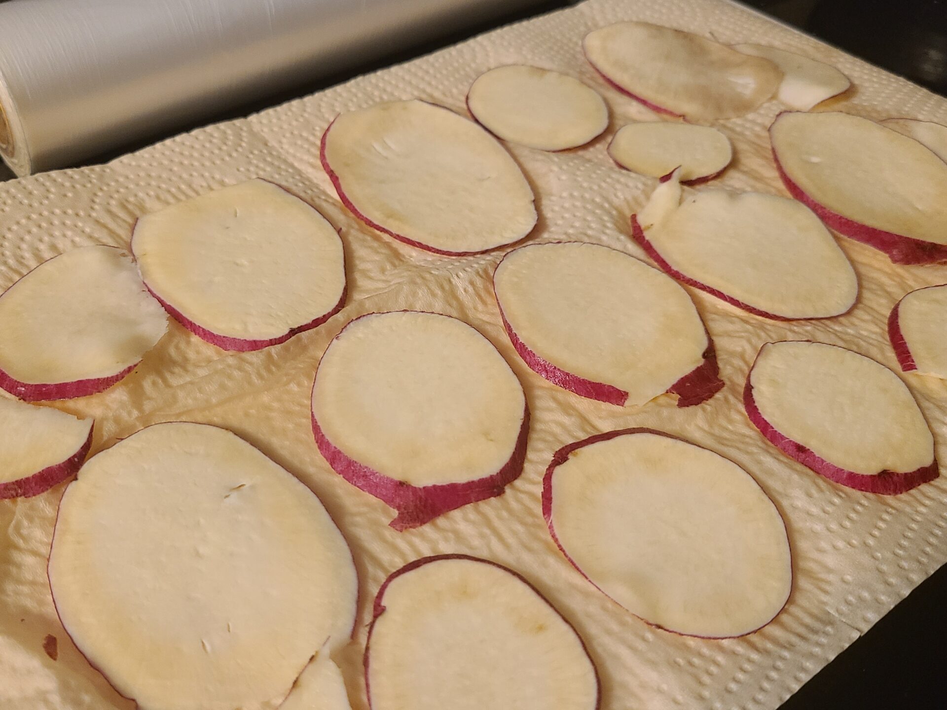 キッチンペーパーの上にスライスされたさつまいもが並んでいる写真