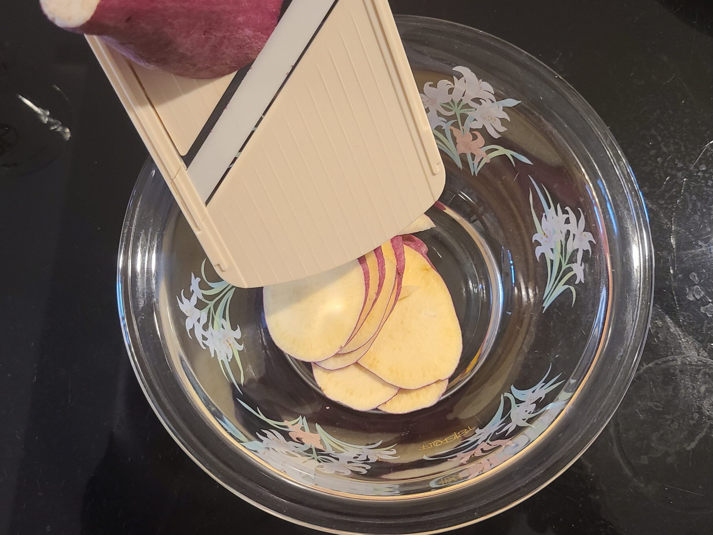 スライサーでさつまいもをスライスしている様子