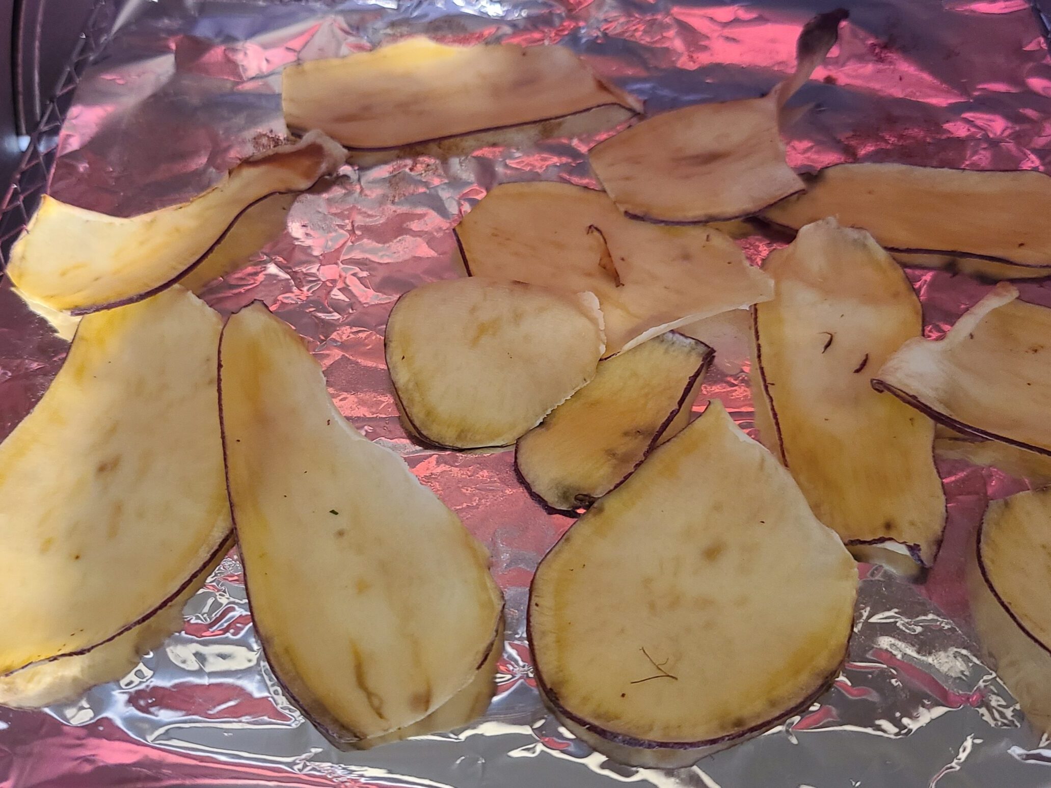 アルミホイルの上に焼かれたさつまいもチップスが並んでいる写真