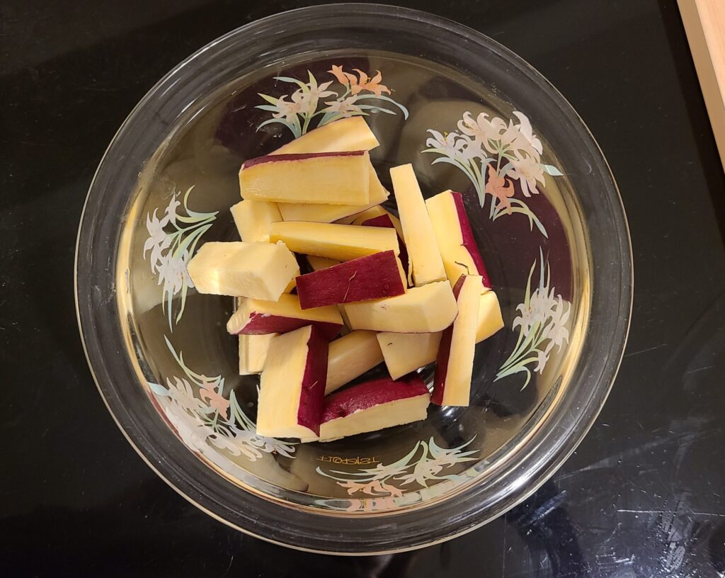 耐熱ボウルにスティック状にカットされたさつまいもが入っている写真