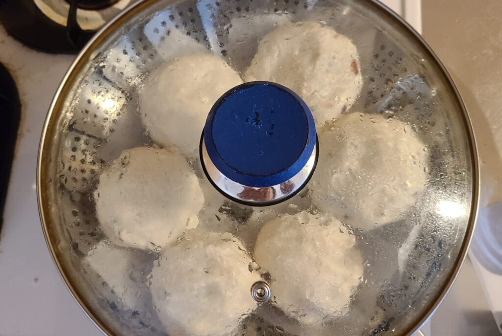 衣で包んださつまいもを蒸し器で蒸している様子